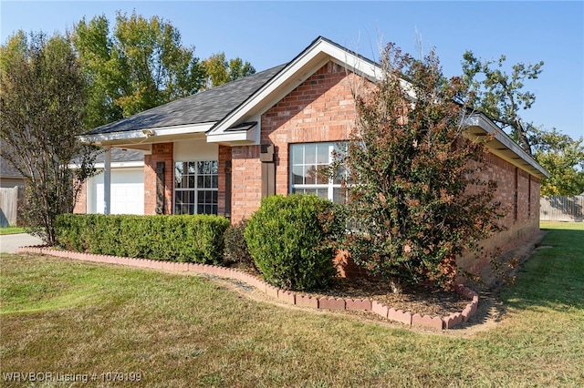 view of property exterior featuring a garage, brick siding, and a lawn