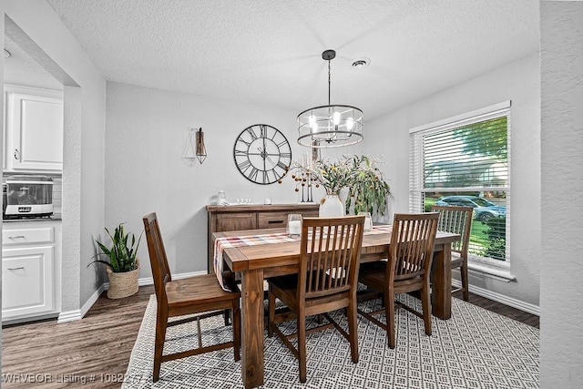 2509 Roxbury Ln, Fort Smith, AR 72908 - dining area featuring a textured ceiling, wood finished floors, a chandelier, and a textured wall