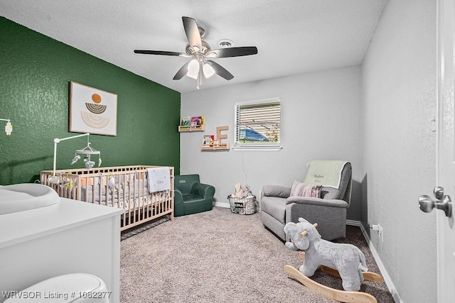 2509 Roxbury Ln, Fort Smith, AR 72908 - carpeted bedroom featuring a nursery area, a textured wall, ceiling fan, and a textured ceiling