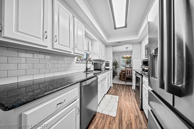 2509 Roxbury Ln, Fort Smith, AR 72908 - kitchen featuring stainless steel appliances, white cabinets, dark wood-style flooring, tasteful backsplash, and dark stone counters