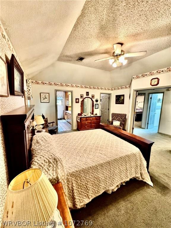 bedroom featuring carpet, a textured ceiling, ceiling fan, and lofted ceiling