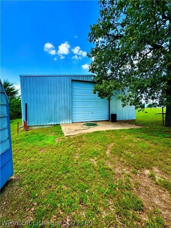 view of outdoor structure with a garage and a lawn