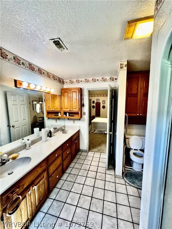 bathroom featuring vanity, a textured ceiling, and tile patterned flooring