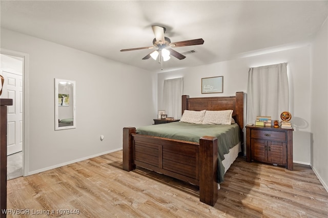 bedroom featuring light wood-style floors, visible vents, baseboards, and a ceiling fan