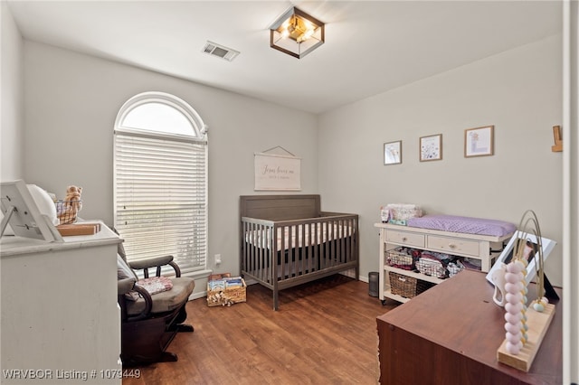 bedroom featuring visible vents and wood finished floors