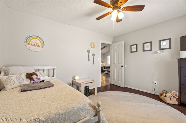 bedroom featuring a ceiling fan, dark wood-style flooring, a textured ceiling, and baseboards