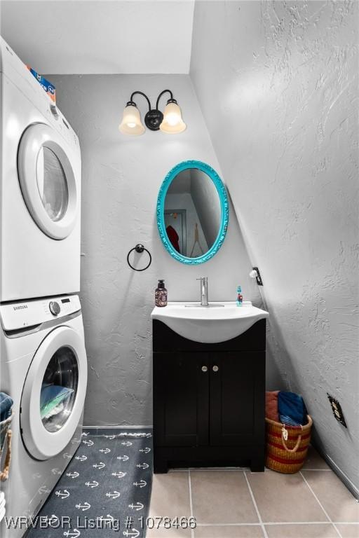 bathroom featuring stacked washer and dryer, tile patterned flooring, and vanity