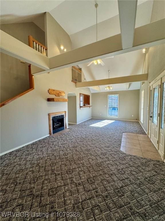 unfurnished living room with high vaulted ceiling, plenty of natural light, carpet flooring, and a fireplace