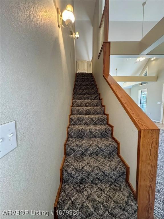 stairway featuring a textured wall