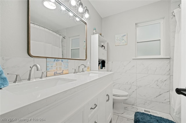 908 N 5th Ter, Barling, AR 72923 - bathroom with marble finish floors, tile walls, double vanity, and toilet