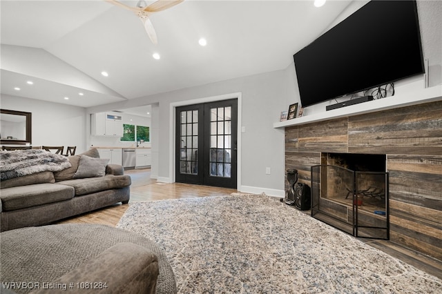 908 N 5th Ter, Barling, AR 72923 - living area featuring lofted ceiling, wood finished floors, french doors, a tiled fireplace, and ceiling fan