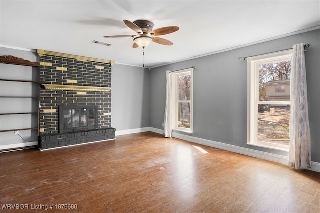 unfurnished living room featuring a fireplace, hardwood / wood-style floors, ceiling fan, and crown molding