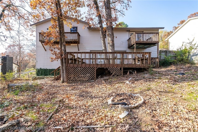 rear view of property with a wooden deck and a balcony