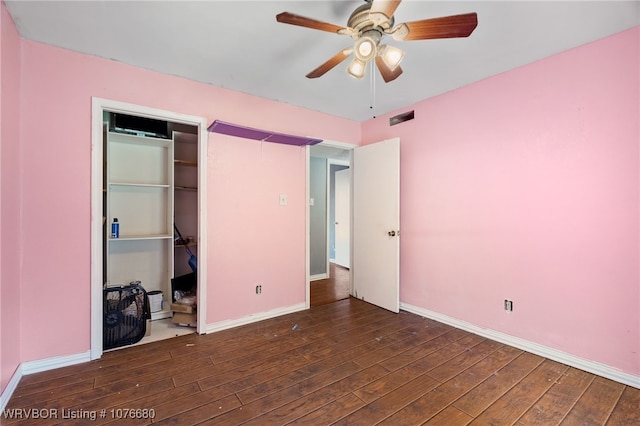 unfurnished bedroom featuring dark hardwood / wood-style floors, ceiling fan, and a closet