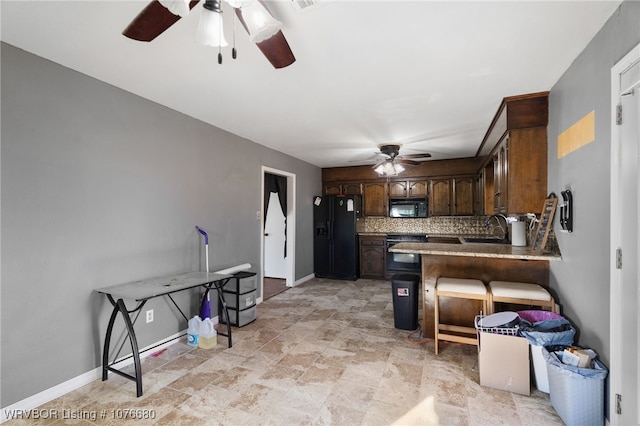 kitchen featuring dark brown cabinetry, sink, backsplash, kitchen peninsula, and black appliances