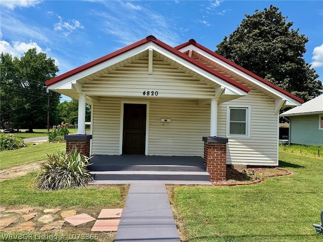 bungalow-style home with covered porch and a front lawn