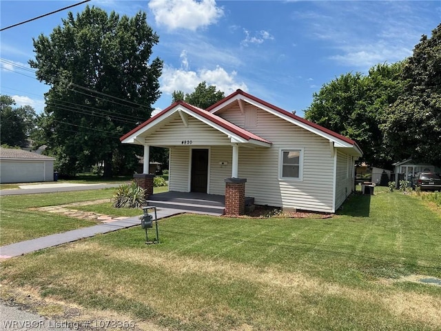 bungalow with covered porch and a front yard