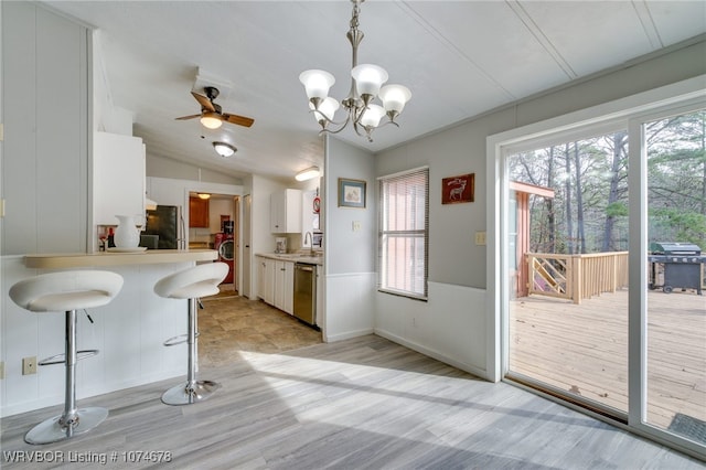 kitchen with white cabinetry, dishwasher, sink, hanging light fixtures, and black fridge