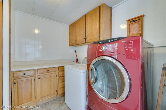 laundry room featuring cabinets, separate washer and dryer, tile walls, and light tile patterned floors