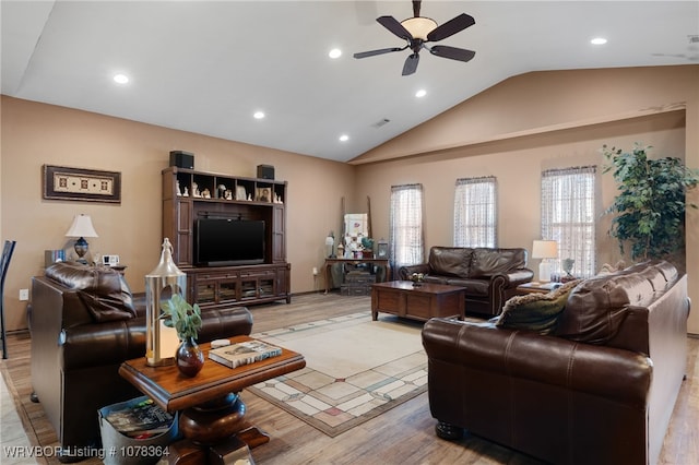 living room featuring vaulted ceiling, light hardwood / wood-style flooring, and ceiling fan