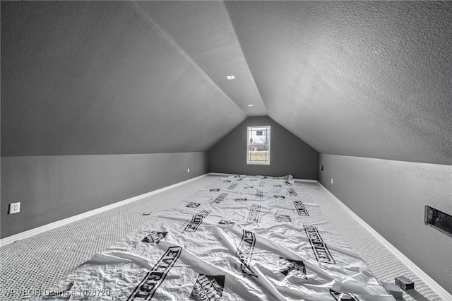 additional living space featuring carpet, lofted ceiling, and a textured ceiling