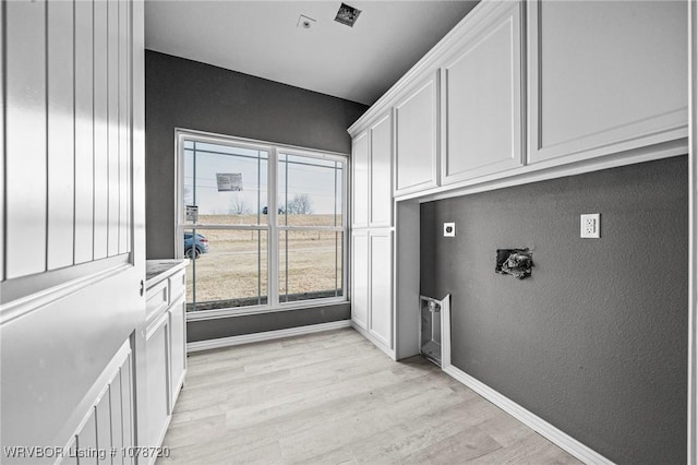 washroom with cabinets, hookup for an electric dryer, and light hardwood / wood-style flooring