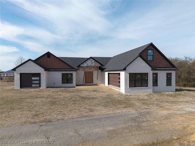 modern farmhouse with a garage and a front lawn