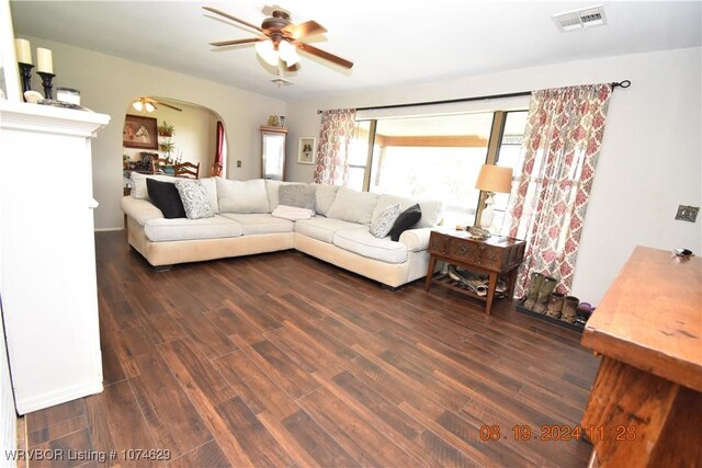 living room with ceiling fan and dark wood-type flooring