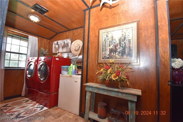 clothes washing area with wood walls, washer and clothes dryer, and wood ceiling