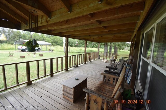 wooden terrace featuring a lawn