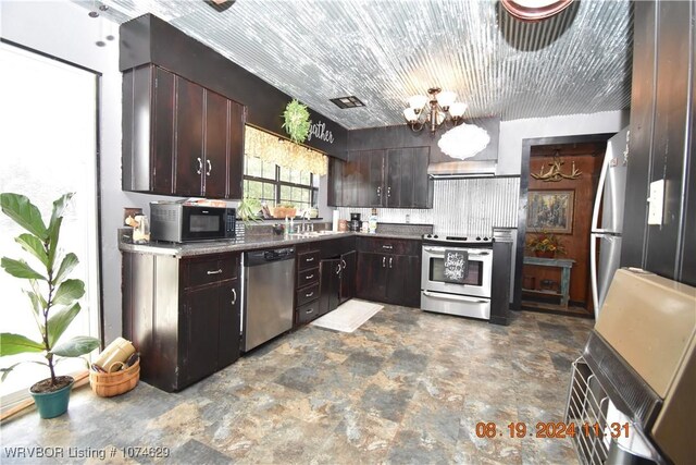 kitchen with sink, wall chimney exhaust hood, a chandelier, dark brown cabinets, and appliances with stainless steel finishes