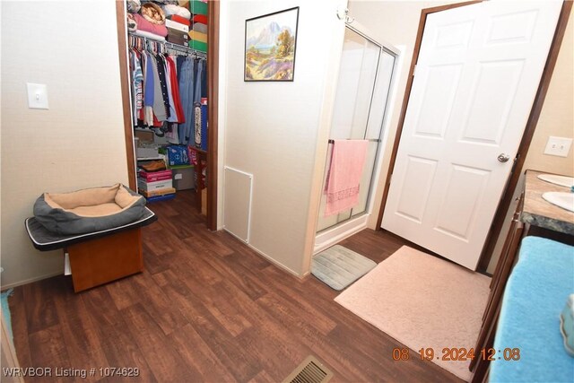 bathroom featuring wood-type flooring, vanity, and walk in shower