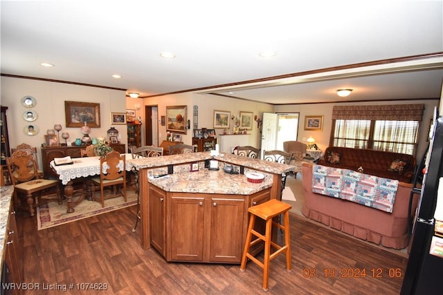 kitchen featuring a kitchen breakfast bar, a center island, dark hardwood / wood-style floors, and ornamental molding