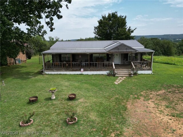 country-style home featuring a front yard, a porch, and a fire pit