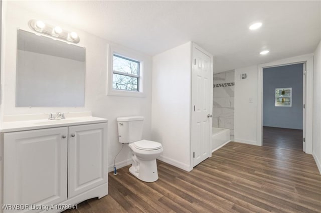 411 N Logan St, Charleston, AR 72933 - full bathroom with vanity, tiled shower / bath combo, wood-type flooring, and toilet