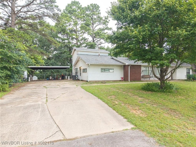 7 Bon Air St, Van Buren, AR 72956 - view of front of house with concrete driveway, a front yard, a shingled roof, and a detached carport