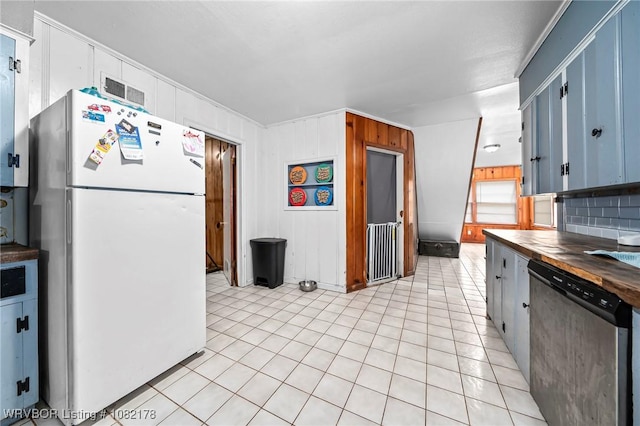 7 Bon Air St, Van Buren, AR 72956 - kitchen with freestanding refrigerator, stainless steel dishwasher, blue cabinets, light tile patterned flooring, and backsplash