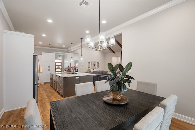 4100 Margate Dr, Fort Smith, AR 72903 - dining area with crown molding, light wood-type flooring, a chandelier, and visible vents