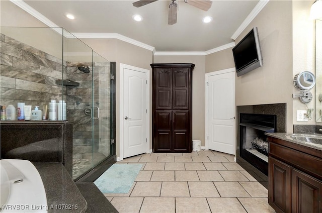 bathroom with tile patterned flooring, vanity, a shower with shower door, and crown molding