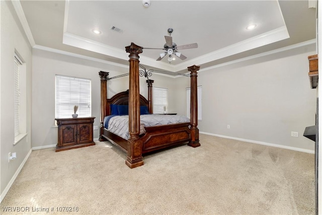 carpeted bedroom with a raised ceiling, ceiling fan, and ornamental molding