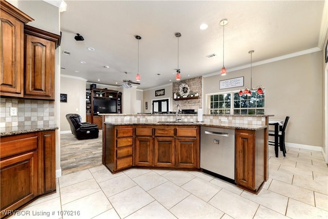 kitchen with a center island with sink, sink, hanging light fixtures, stainless steel dishwasher, and ceiling fan