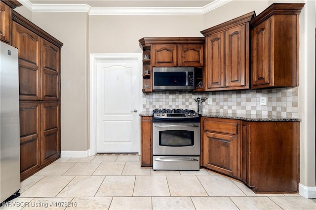 kitchen featuring tasteful backsplash, dark stone countertops, ornamental molding, and appliances with stainless steel finishes