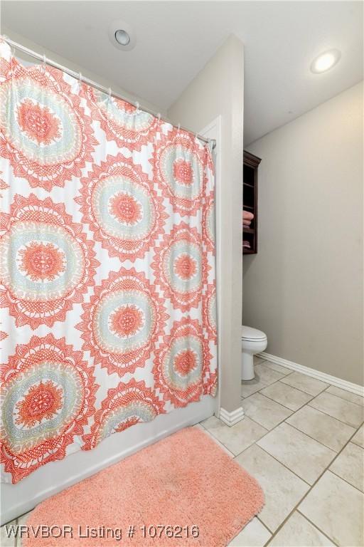 bathroom featuring tile patterned flooring, shower / bath combo, and toilet