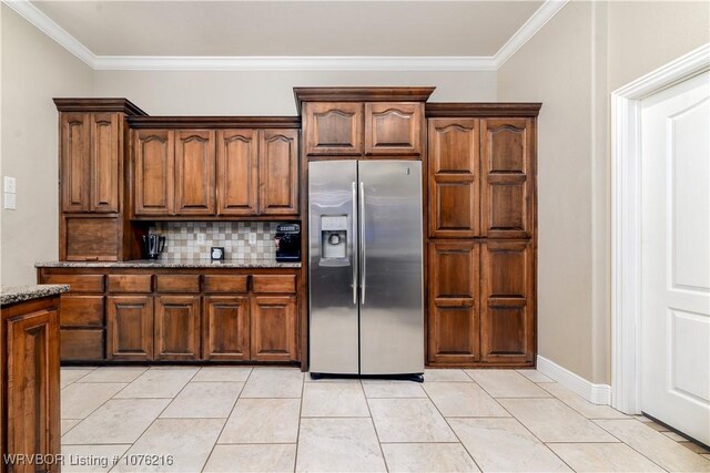 kitchen featuring crown molding, stainless steel fridge with ice dispenser, backsplash, and light tile patterned floors