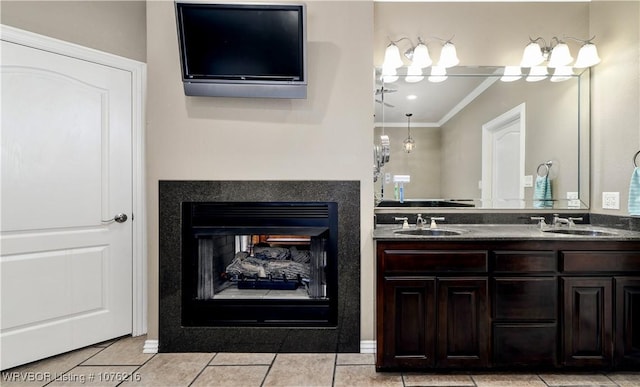 bathroom with a multi sided fireplace, vanity, tile patterned flooring, and crown molding