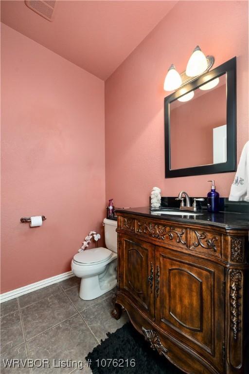 bathroom featuring tile patterned floors, vanity, toilet, and lofted ceiling