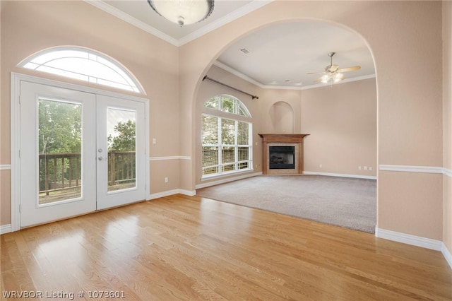 unfurnished living room featuring a healthy amount of sunlight, french doors, ceiling fan, and ornamental molding