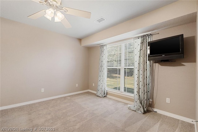 empty room featuring ceiling fan and light carpet