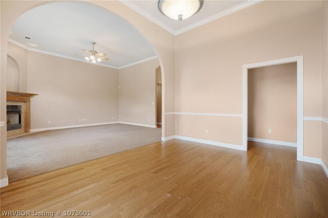 unfurnished living room with crown molding, ceiling fan, and wood-type flooring