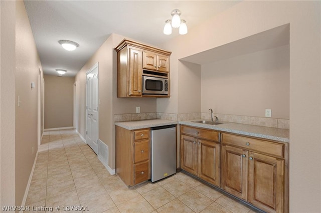 kitchen with sink, light tile patterned floors, and appliances with stainless steel finishes